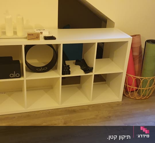 מדף עם ציוד כושר ויוגה, כולל גלילים ומחצלות
